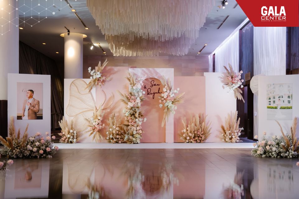 Backdrop chụp ảnh tông hồng - kem với hoa và nền tối giản tại sảnh đón khách Gala Center